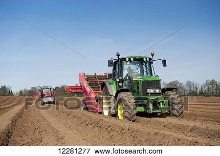 Stock Photo - Preparing potato seed bed, using Grimme stone removing machine pulled by a John Deere 6930; Yorkshire, England. Fotosearch