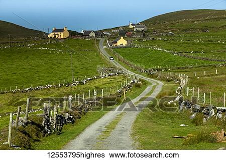 Stock Photograph - Road leading by pastures to houses on a hillside on Dursey Island on the Beara peninsula, Wild Atlantic Way; Dursey Island, County Cork, Ireland. Fotosearch