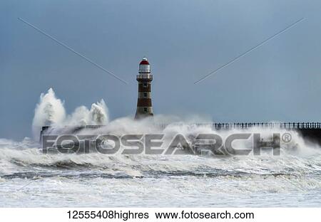 Stock Photograph - Roker Lighthouse and waves from the River Ware crashing onto the pier; Sunderland, Tyne and Wear, England. Fotosearch