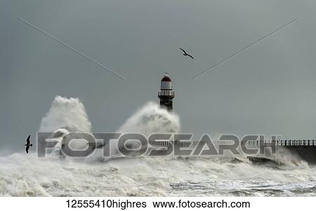 Stock Photograph - Roker Lighthouse and waves from the River Ware crashing onto the pier; Sunderland, Tyne and Wear, England. Fotosearch