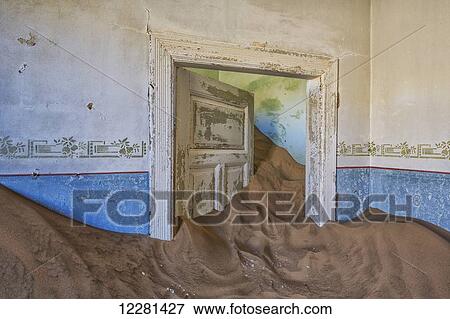 Stock Photo - Sand in the rooms of a colourful and abandoned house; Kolmanskop, Namibia. Fotosearch