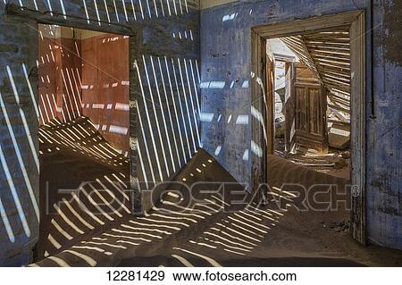 Stock Photo - Sand in the rooms of a colourful and abandoned house; Kolmanskop, Namibia. Fotosearch