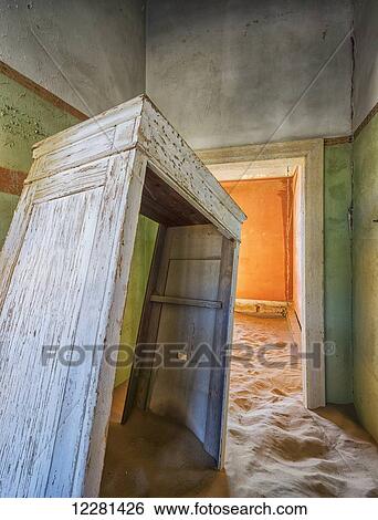 Stock Photograph - Sand in the rooms of a colourful and abandoned house; Kolmanskop, Namibia. Fotosearch