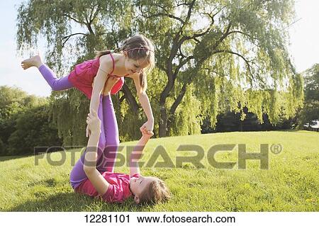 Sisters playing balancing game in park; Toronto, Ontario, Canada View Large Photo Image Stock Image - Sisters playing balancing game in park; Toronto, Ontario, Canada. Fotosearch