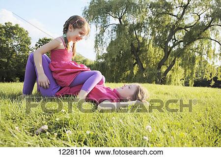 Sisters playing in a park; Toronto, Ontario, Canada View Large Photo Image Picture - Sisters playing in a park; Toronto, Ontario, Canada. Fotosearch