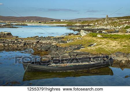 Small wooden rowboat moored along the shore of Galway Bay on Mweenish Island, Wild Atlantic Way; Mweenish Island, County Galway, Ireland View Large Photo Image Stock Photograph - Small wooden rowboat moored along the shore of Galway Bay on Mweenish Island, Wild Atlantic Way; Mweenish Island, County Galway, Ireland. Fotosearch