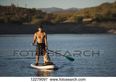 Stock Photo - Stand up paddle boarding on tranquil Lake Pleasant; Arizona, United States of America. Fotosearch