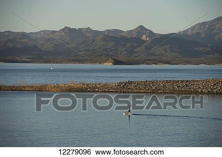 Stock Photograph - Stand up paddle boarding on tranquil Lake Pleasant; Arizona, United States of America. Fotosearch