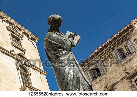 Stock Photograph - Statue of Marko Marulic, father of Croatian literature, by Ivan Mestrovic in front of the Milesi Palace in Fruit Square; Split, Croatia. Fotosearch
