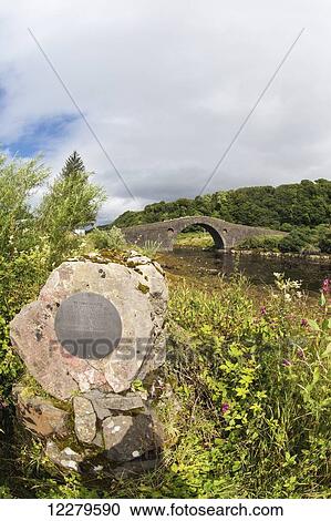 Stone memorial in the foreground with a stone bridge crossing a stream in the background; Clachan-Seil, Scotland View Large Photo Image Stock Image - Stone memorial in the foreground with a stone bridge crossing a stream in the background; Clachan-Seil, Scotland. Fotosearch