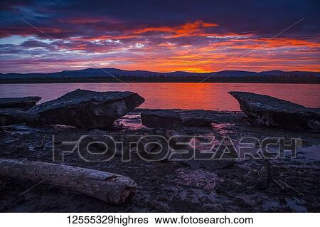 Stock Photograph - Sunset over icebergs on the Yukon River at Slaven's Roadhouse in summertime, Yukon-Charley Rivers National Preserve; Alaska, United States of America. Fotosearch