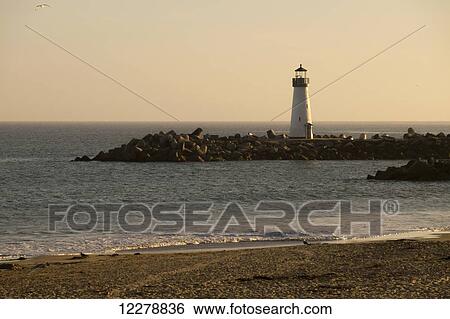 Stock Photograph - Sunset over the Walton Lighthouse at the Santa Cruz Harbor and Monterey Bay; California, United States of America. Fotosearch