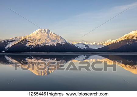 Turnagain Arm, South of Anchorage, Alaska in the morning. Ocean waters are calm and provides a good reflection of the mountains in the water; Alaska, United States of America View Large Photo Image Stock Photograph - Turnagain Arm, South of Anchorage, Alaska in the morning. Ocean waters are calm and provides a good reflection of the mountains in the water; Alaska, United States of America. Fotosearch