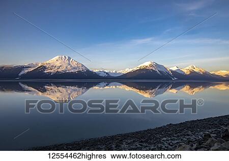 Turnagain Arm, South of Anchorage, Alaska in the morning. Ocean waters are calm and provides a good reflection of the mountains in the water; Alaska, United States of America View Large Photo Image Stock Photograph - Turnagain Arm, South of Anchorage, Alaska in the morning. Ocean waters are calm and provides a good reflection of the mountains in the water; Alaska, United States of America. Fotosearch