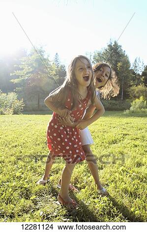 Picture - Two young girls playing in a park; Kinmount, Ontario, Canada. Fotosearch