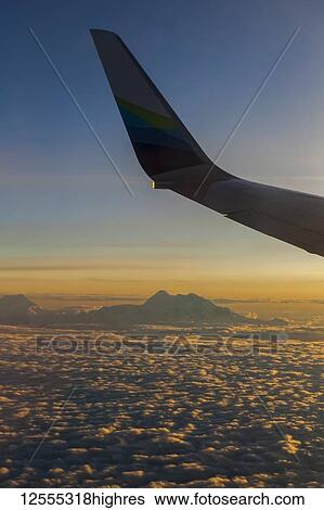 Stock Photograph - View of Denali and Alaska Range from the North taken at sunset on Alaska Airlines jet; Alaska, United States of America. Fotosearch