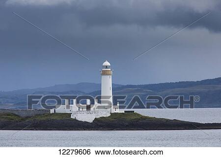 Stock Photograph - White lighthouse under storm clouds along the coast; Scotland. Fotosearch