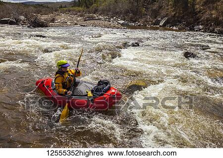 Woman packrafter negotiating a technical rapid on the tributary of the Charley River with aufeis in summertime, YukonCharley Rivers National Preserve; Alaska, United States of America View Large Photo Image Stock Photograph - Woman packrafter negotiating a technical rapid on the tributary of the Charley River with aufeis in summertime, YukonCharley Rivers National Preserve; Alaska, United States of America. Fotosearch