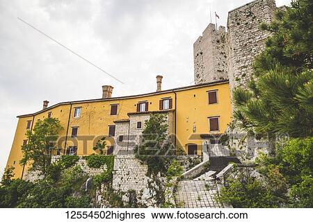 Stock Photograph - Yellow and stone walls of Duino Castle; Italy. Fotosearch