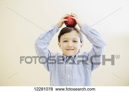 Young boy balancing an apple on his head View Large Photo Image Stock Photo - Young boy balancing an apple on his head. Fotosearch