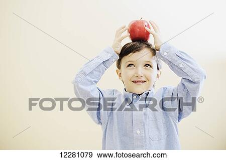 Young boy balancing an apple on his head View Large Photo Image Stock Photo - Young boy balancing an apple on his head. Fotosearch