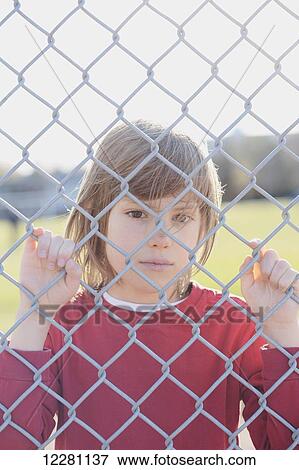 Young boy behind a fence; Toronto, Ontario, Canada View Large Photo Image Stock Photo - Young boy behind a fence; Toronto, Ontario, Canada. Fotosearch
