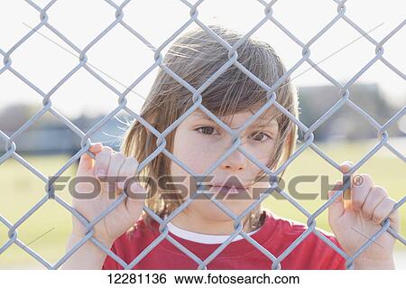Stock Photograph - Young boy behind a fence; Toronto, Ontario, Canada. Fotosearch