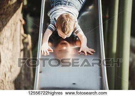 Young boy going down head-first on a playground slide; Edmonton, Alberta, Canada View Large Photo Image Stock Photograph - Young boy going down head-first on a playground slide; Edmonton, Alberta, Canada. Fotosearch
