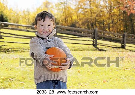 Stock Photo - Young Boy Holding Pumpkin, Stayner, Ontario. Fotosearch