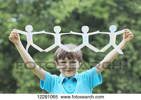 Young boy holding up string of paper dolls; Toronto, Ontario, Canada View Large Photo Image Stock Photography - Young boy holding up string of paper dolls; Toronto, Ontario, Canada. Fotosearch