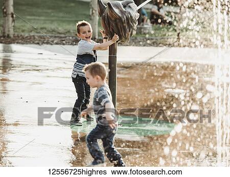 Stock Photograph - Young boys at a spray park; Edmonton, Alberta, Canada. Fotosearch