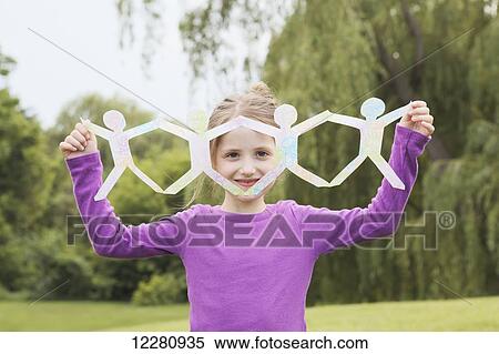 Young girl holding up string of paper dolls; Toronto, Ontario, Canada View Large Photo Image Stock Photography - Young girl holding up string of paper dolls; Toronto, Ontario, Canada. Fotosearch