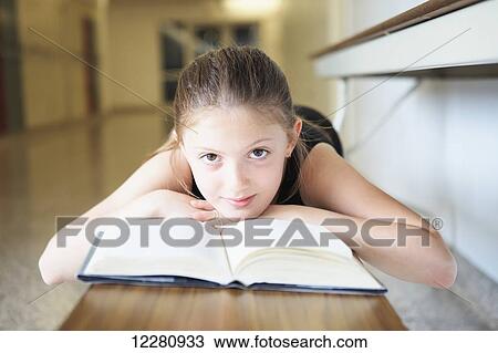 Young girl laying on bench reading a book; Toronto, Ontario, Canada View Large Photo Image Stock Image - Young girl laying on bench reading a book; Toronto, Ontario, Canada. Fotosearch