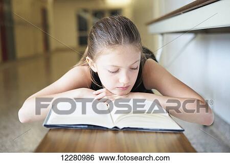 Young girl laying on bench reading a book; Toronto, Ontario, Canada View Large Photo Image Stock Photograph - Young girl laying on bench reading a book; Toronto, Ontario, Canada. Fotosearch