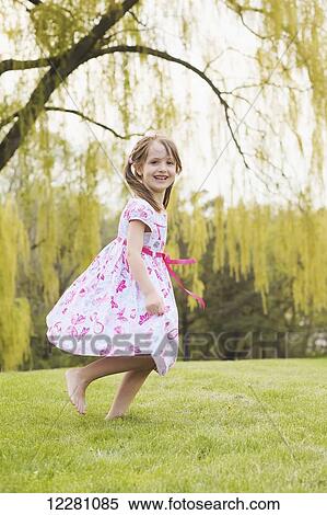 Young girl running in a floral dress; Toronto, Ontario, Canada View Large Photo Image Stock Photography - Young girl running in a floral dress; Toronto, Ontario, Canada. Fotosearch