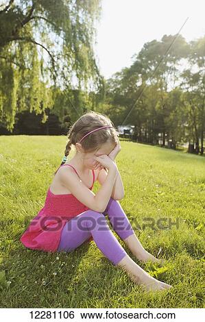Young girl sitting on grass covering her face; Toronto, Ontario, Canada View Large Photo Image Stock Photograph - Young girl sitting on grass covering her face; Toronto, Ontario, Canada. Fotosearch
