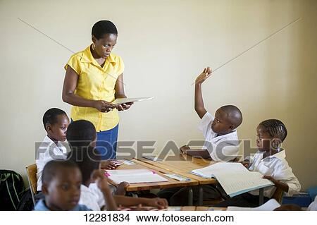 Young students with a teacher in a classroom; Hammanskraal, Gautang, South Africa View Large Photo Image Picture - Young students with a teacher in a classroom; Hammanskraal, Gautang, South Africa. Fotosearch