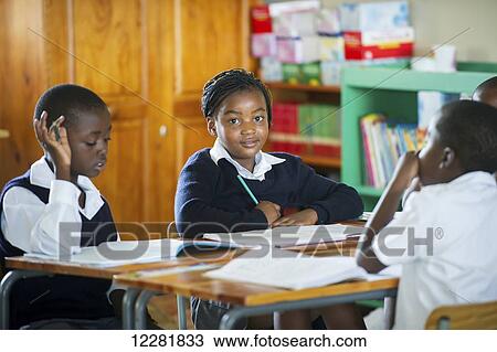 Stock Image - Young students working in a classroom; Hammanskraal, Gautang, South Africa. Fotosearch