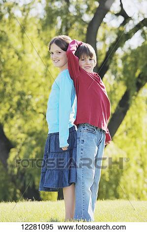 Younger brother measuring his height against older sister; Toronto, Ontario, Canada View Large Photo Image Stock Photography - Younger brother measuring his height against older sister; Toronto, Ontario, Canada. Fotosearch