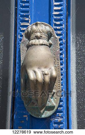 Stock Photo - A brass door knocker in the shape of a hand; Apollonia, Sifnos, Cyclades, Greek Islands, Greece. Fotosearch