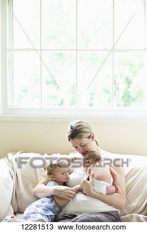 A mother cuddles with her toddler and newborn baby; Nashville, Tennessee, United States of America View Large Photo Image Stock Image - A mother cuddles with her toddler and newborn baby; Nashville, Tennessee, United States of America. Fotosearch