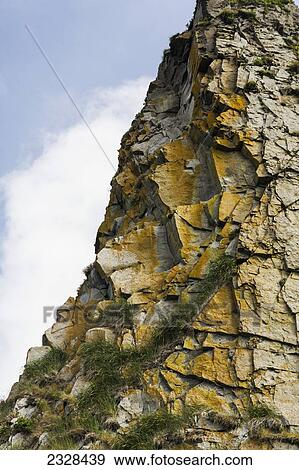 Stock Photo - A Stone Cliff On The The Alaska Peninsula, Across From The Town Of False Pass On Unimak Island, Isanotski Strait; Southwest Alaska, United States Of America. Fotosearch