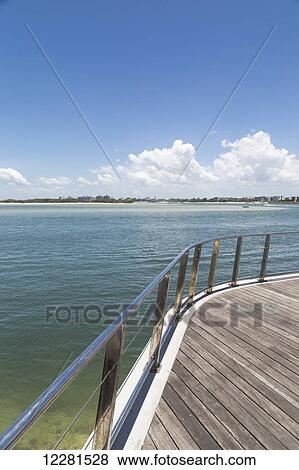 A wooden boat deck and railing with a view of the coastline; Caloundra, Queensland, Australia View Large Photo Image Stock Photo - A wooden boat deck and railing with a view of the coastline; Caloundra, Queensland, Australia. Fotosearch