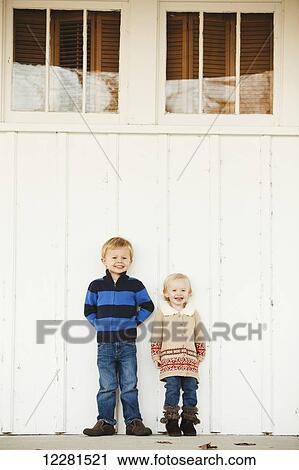 A young boy and girl stand side by side against a white wall; Nashville, Tennessee, United States of America View Large Photo Image Stock Image - A young boy and girl stand side by side against a white wall; Nashville, Tennessee, United States of America. Fotosearch