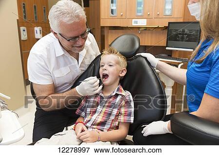 Stock Photo - A young boy at a dental examination; Edmonton, Alberta, Canada. Fotosearch