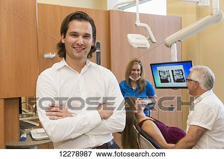 Associate dentist posing during patient consultation; Edmonton, Alberta, Canada View Large Photo Image Stock Photo - Associate dentist posing during patient consultation; Edmonton, Alberta, Canada. Fotosearch