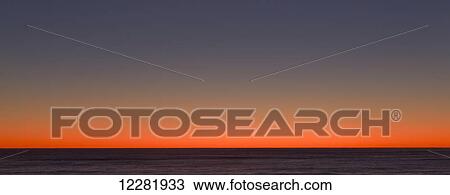 Stock Image - Beautiful burnt orange sunset, taken in the West Coast; South Island, New Zealand. Fotosearch