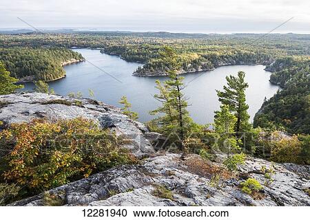 Stock Image - Beautiful view of a fall forest and George Lake from the mountain top; Killarney, Ontario, Canada. Fotosearch