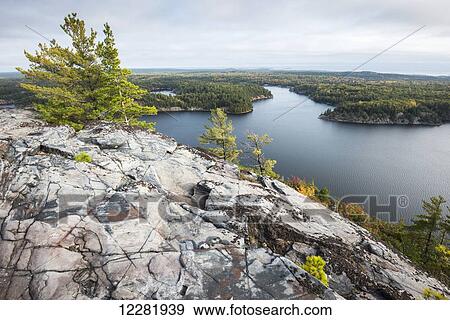 Stock Photo - Beautiful view of a fall forest and George Lake from the mountain top; Killarney, Ontario, Canada. Fotosearch