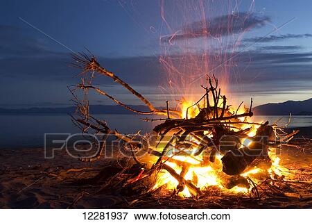 Stock Photo - Bonfire on the beach at Golden Bay, New Years Eve; South Island, New Zealand. Fotosearch